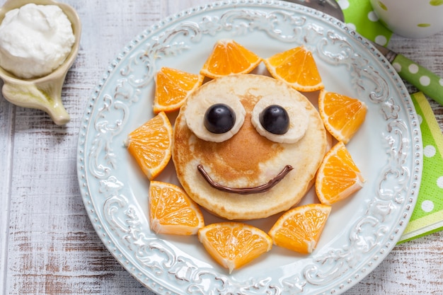 Pancakes con arancia, uva e banana per bambini