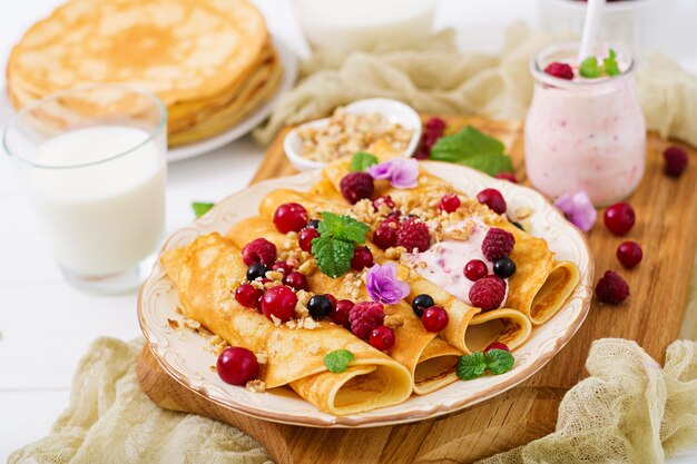 Pancakes con yogurt, miele, noci e frutti di bosco estivi. Gustosa colazione