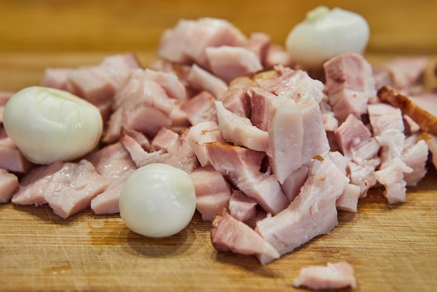 Pancetta affettata con cipolle in cucina su un tagliere pronto per la cottura