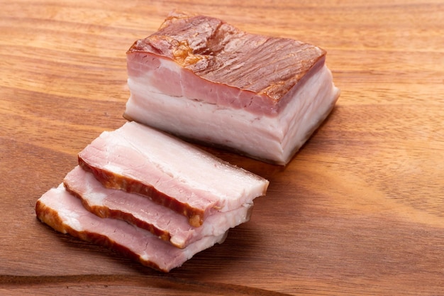 Pancetta affumicata affettata su una tavola di legno