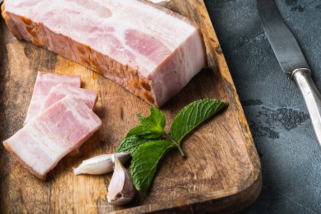 Pancetta affumicata con spezie su una tavola di legno