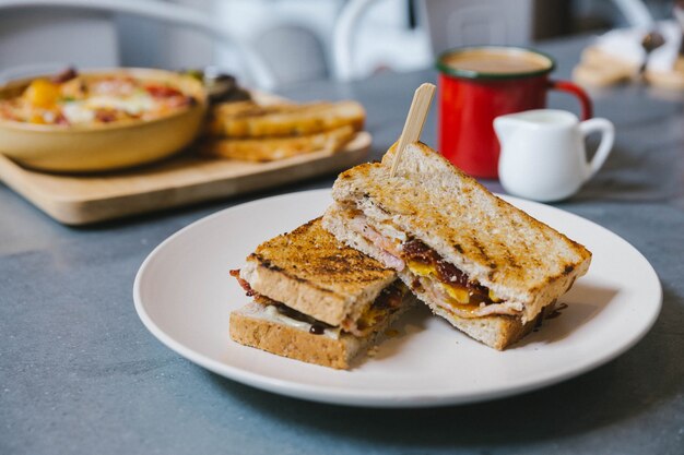 Pancetta croccante ripiena toast alla francese con uovo fritto. Servito con caffè e latte