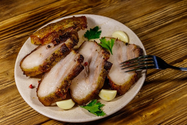 Pancetta di maiale al forno in un piatto sulla tavola di legno