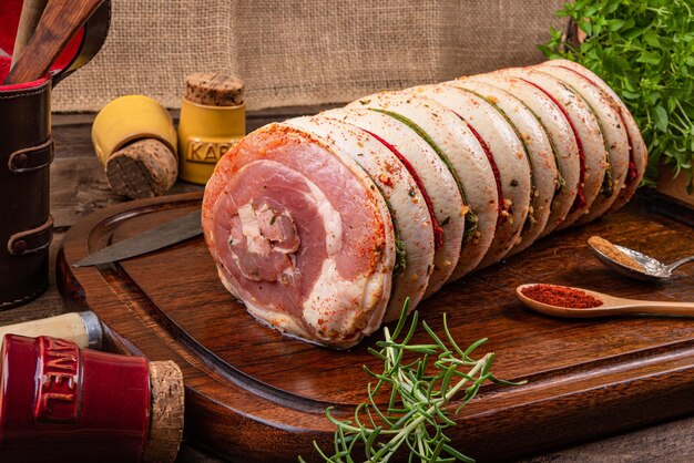 Pancetta di maiale arrotolata su tavola di legno e spezie