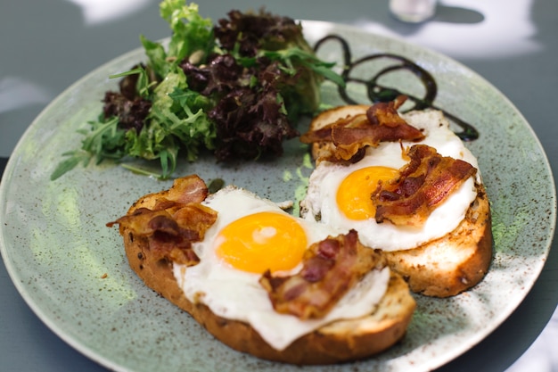 Pancetta e uova fritte su pane tostato con decotto di lattuga