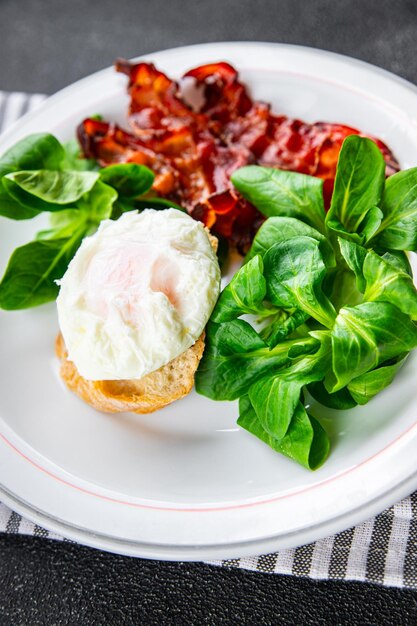 pancetta per la colazione con uova in camicia, insalata di foglie verdi mix pasto sano spuntino sullo spazio della copia del tavolo