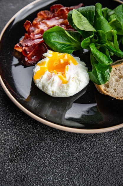 pancetta per la colazione con uova in camicia, insalata di foglie verdi mix pasto sano spuntino sullo spazio della copia del tavolo