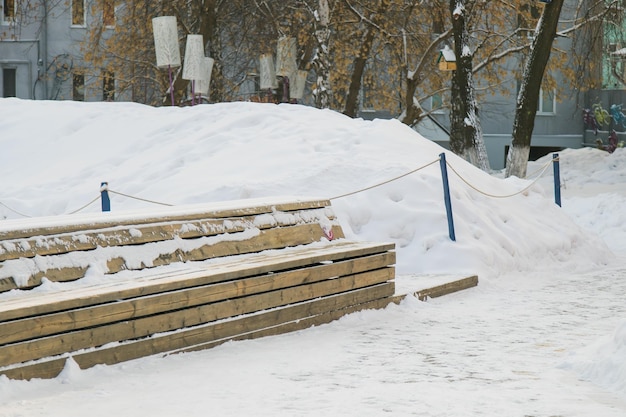 Panchina nel parco con la neve in stagione invernale Città e strada della città