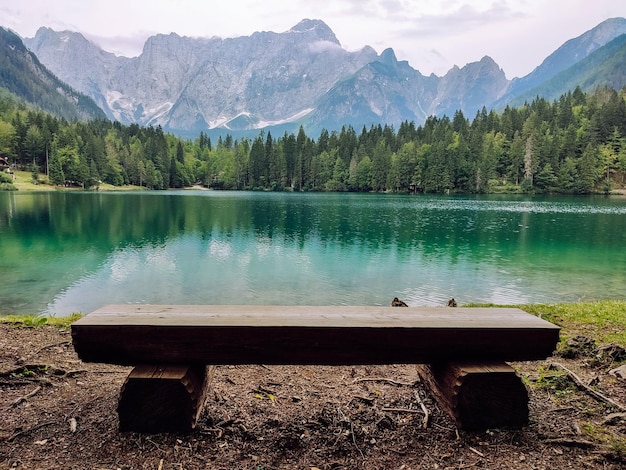 Panchina sulla riva di un lago di montagna con un bellissimo paesaggio di montagna nel pomeriggio