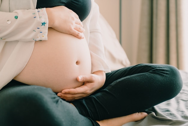 Pancia della donna incinta con le mani