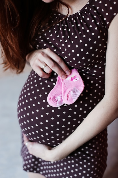 Pancia di una donna incinta con i calzini