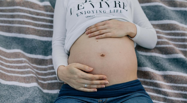 Pancia incinta sdraiata su una coperta