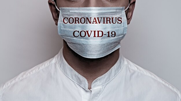 Pandemia di coronavirus. Concetto di quarantena del virus Corona, Covid-19. Il volto maschile è coperto da una maschera medica protettiva