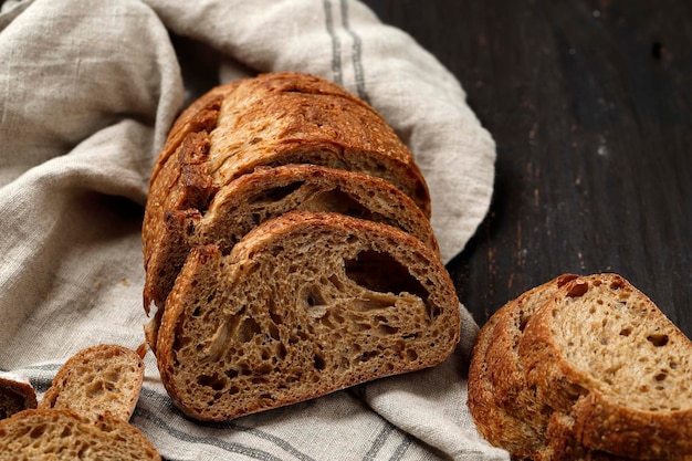 Pane a lievitazione naturale di farro tradizionale tagliato a fette su uno sfondo di legno rustico Texture rustica di pane