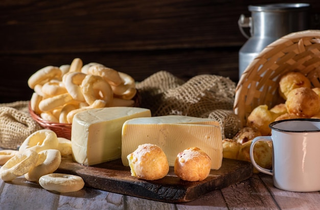 Pane al formaggio e altro pane al formaggio Biscotti di farina di manioca e formaggio Minas disposti su una superficie di legno rustica con messa a fuoco selettiva degli accessori