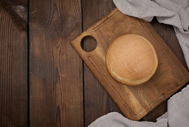 Pane al forno rotondo su una tavola di legno marrone del bordo