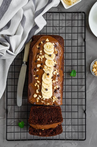 Pane alla banana al cioccolato fatto in casa con crema al cioccolato, fette di banana e noci in cima