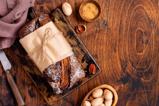 Pane alla banana con croccante alla cannella e cosparso di zucchero a velo su un tavolo di cemento leggero.