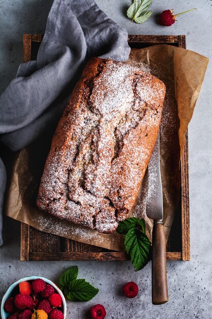 Pane alla banana con lampone, bundt sulla superficie vintage di cemento grigio