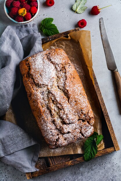 Pane alla banana con lampone, bundt sulla superficie vintage di cemento grigio