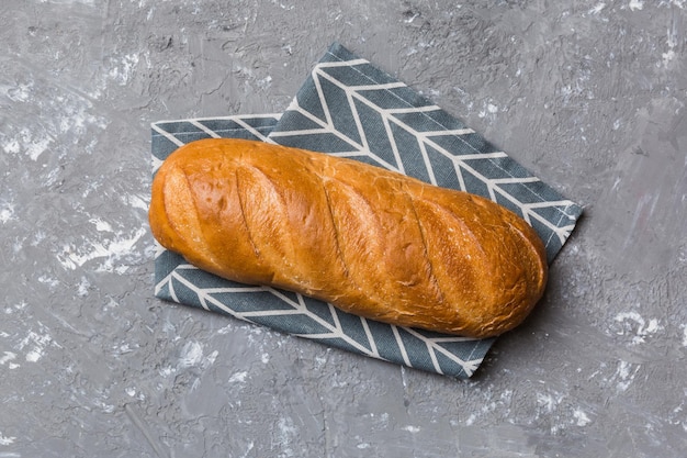 Pane appena sfornato con tovagliolo su tavolo rustico vista dall'alto Pane bianco sano isolato