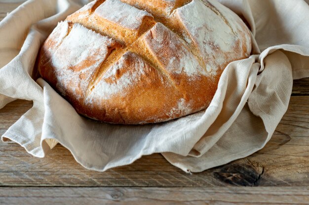 Pane appena sfornato sul tavolo da cucina grigio in legno, pasticceria fatta in casa.