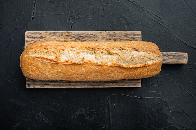 Pane baguette appena sfornato, su sfondo nero, vista dall'alto laici piatta