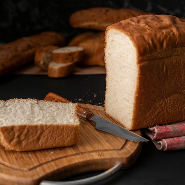 Pane bianco affettato appena sfornato con coltello di metallo, toast per cucinare i sandwitch