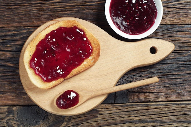 Pane bianco con marmellata di fragole sul tagliere, vista dall'alto