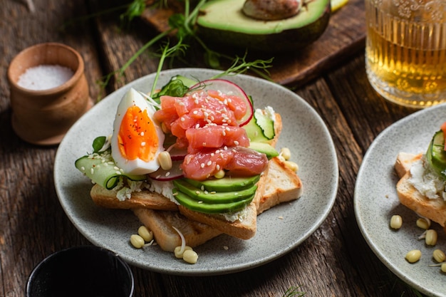 Pane bianco toast con formaggio cremoso uovo di salmone avocado cetriolo e ravanello in un piatto