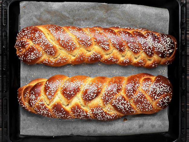 Pane challah fatto in casa con semi di sesamo su una teglia