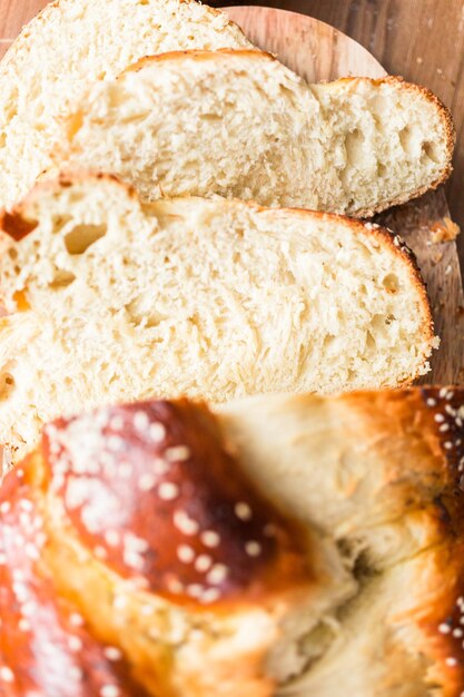 Pane challah fresco affettato sul tavolo di legno.