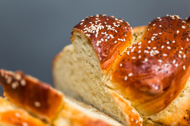 Pane challah fresco affettato sul tavolo di legno.