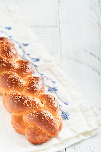 Pane Challah Sabbath kiddush cerimonia composizione Pane challah intrecciato fatto in casa appena sfornato per Shabbat e vacanze su sfondo bianco di legno Shabbat Shalom Vista dall'alto Spazio di copia