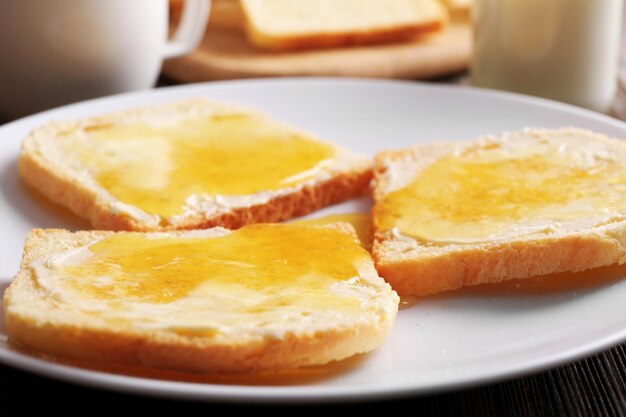 Pane con burro e marmellata fatta in casa in primo piano piatto bianco