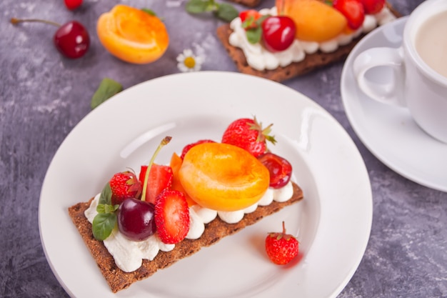 Pane con crema di formaggio, frutta e frutti di bosco