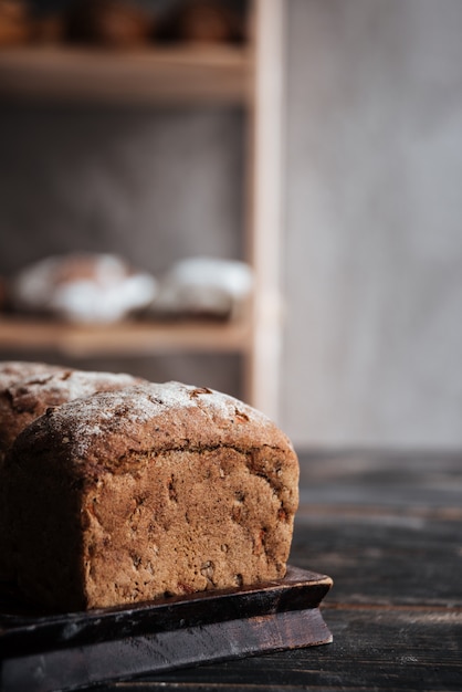 Pane con farina sulla tavola di legno scura