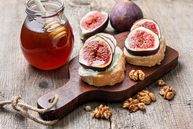 Pane con fichi, ricotta su fondo in legno vecchio