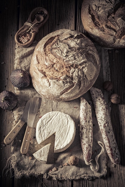 Pane con formaggio, salsiccia e noci su tela di lino