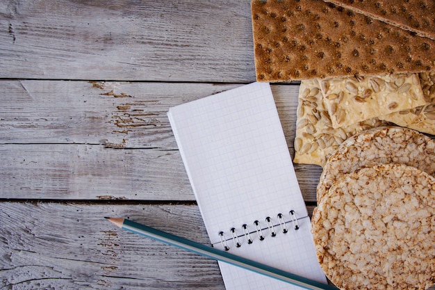 pane croccante, fiocchi, grano saraceno, biscotti con girasole su uno sfondo a trama