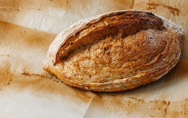 Pane croccante rustico dorato da forno su uno sfondo di carta da forno ripresa dall'alto