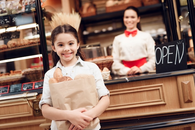 Pane d&#39;acquisto sorridente della giovane ragazza in forno moderno.