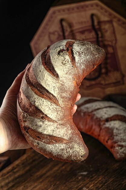 Pane d'epoca foto originale pane di frumento crudo Una mano che tiene una pagnotta di pane