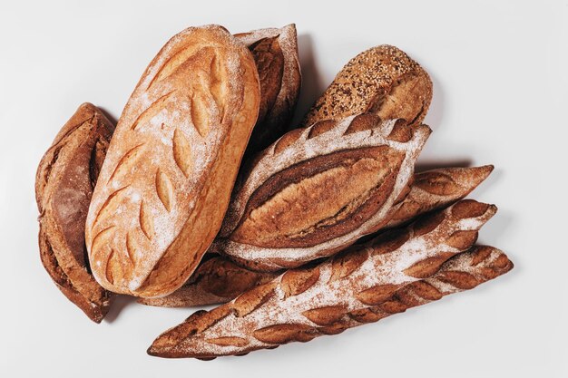 Pane da forno pagnotte croccanti rustiche fresche di pane e baguette su fondo bianco