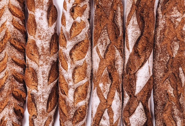 Pane da forno pagnotte croccanti rustiche fresche di pane e baguette su fondo bianco