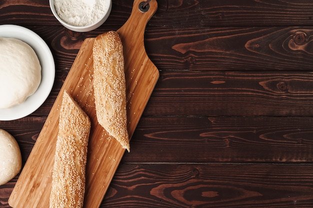 Pane delle baguette sulla fine del bordo di legno marrone su