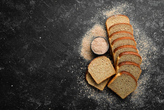 Pane di crusca fresca Cottura Vista dall'alto Sfondo in pietra nera in stile rustico