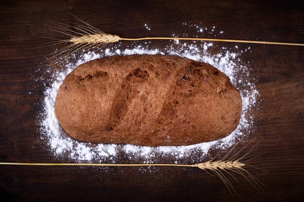 Pane di forma ellittica su un legno, pane da una stufa su tavole scure