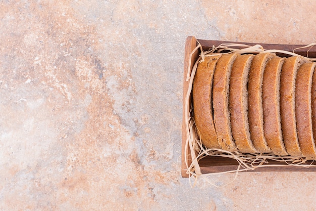 Pane di grano su una cannuccia in una scatola di legno, sullo sfondo di marmo.