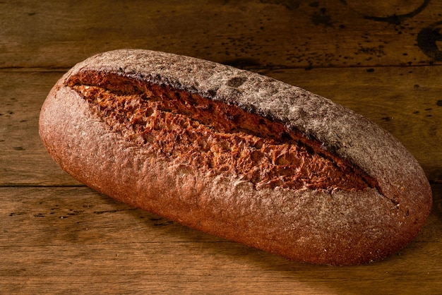 Pane di segale appena sfornato su tavola di legno Sfondo di legno